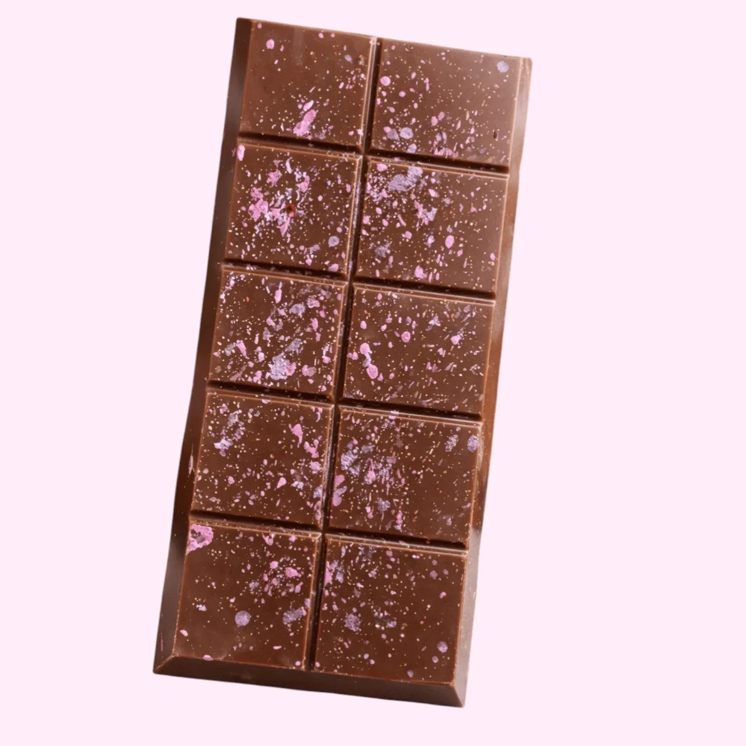 Chocolate bar with pink specks on a light gray surface