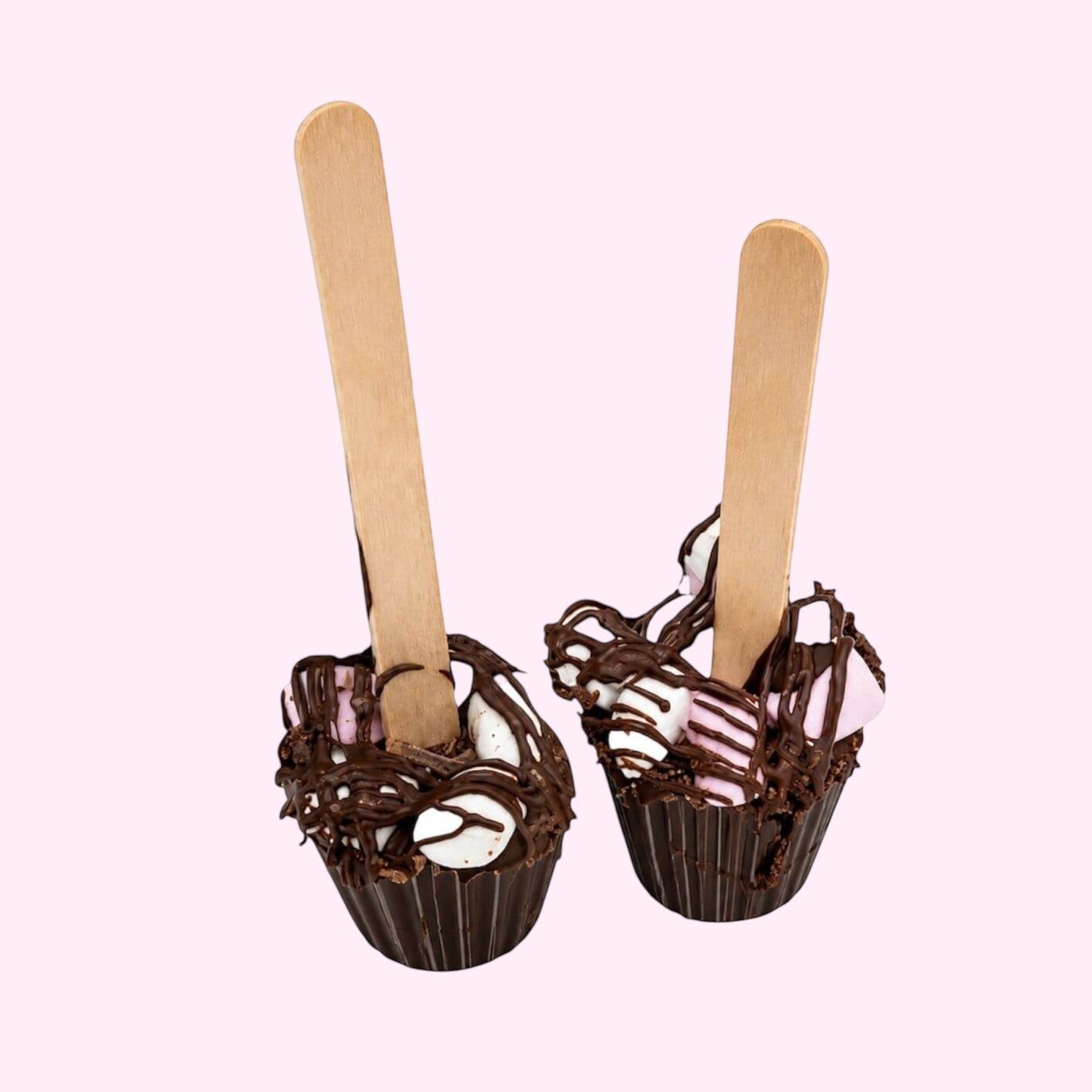 Sweet Snap Sydney hot chocolate bombs with marshmallows and chocolate drizzle on wooden sticks.