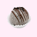 Sweet Snap Sydney Oreo hot chocolate bomb with chocolate drizzle and cookie crumbles, in a white paper liner.