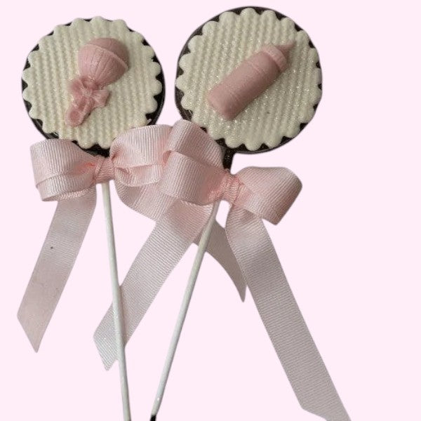 Sweet Snap Sydney baby shower chocolate lollies with pink baby bottle and rattle decorations, tied with pink bows.