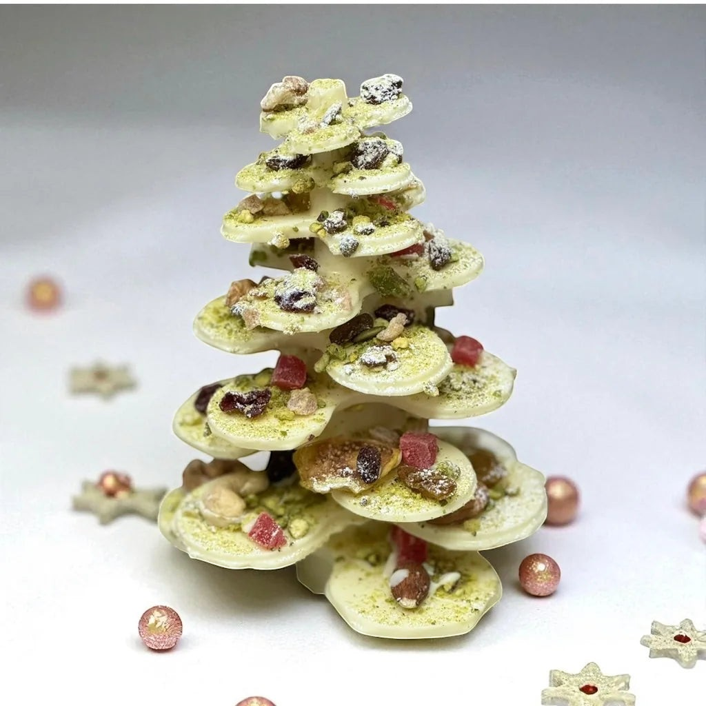 White chocolate and pistachio Christmas tree decorated with dried fruit and nuts